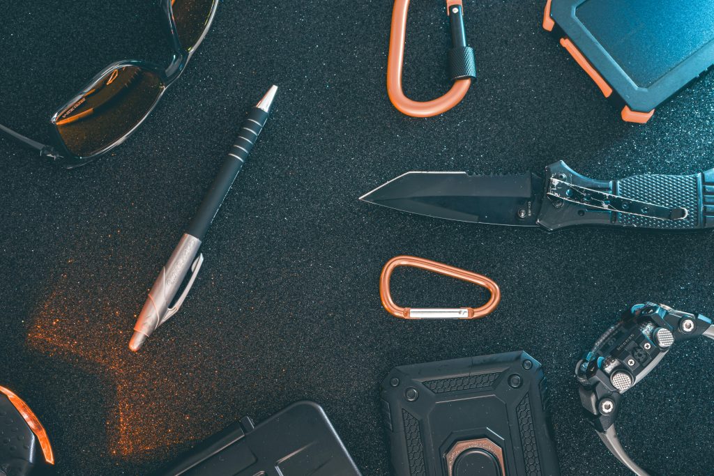 Flat lay of some Outdoor/EDC gear on a dark background.